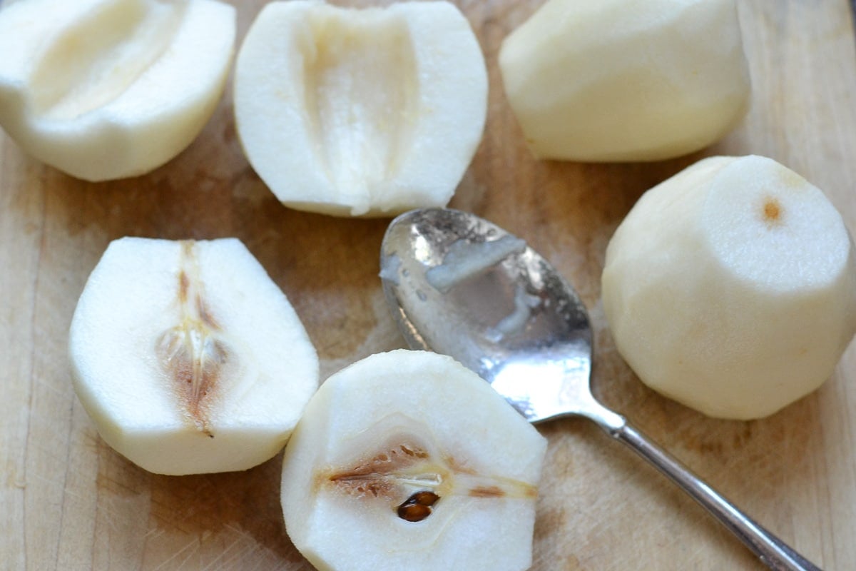 several cut and peeled pears with the cores scooped out.