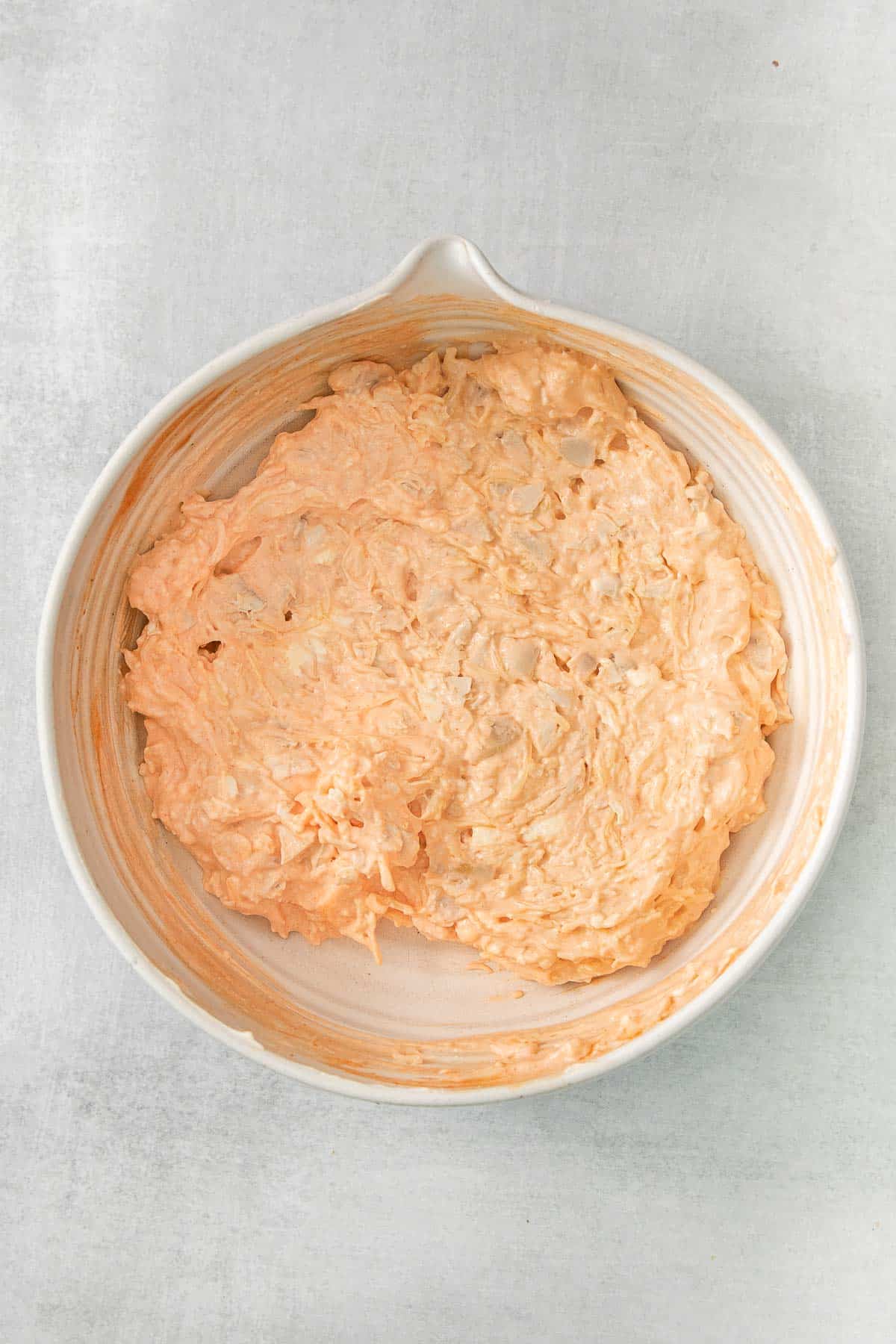 buffalo chicken and cream cheese mixture in a white mixing bowl.