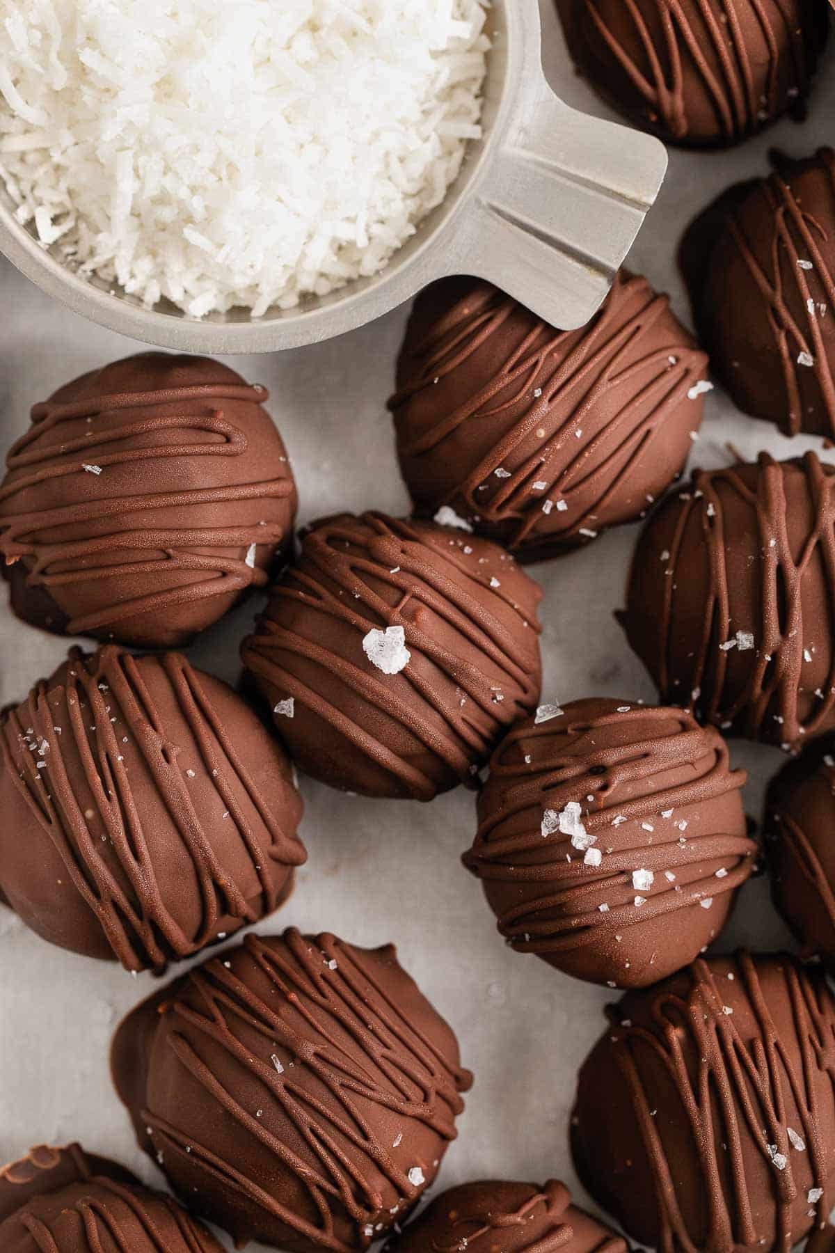 closeup of chocolate covered coconut balls drizzled with extra chocolate.