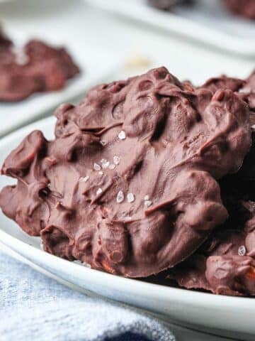 chocolate covered peanut cluster on a white plate.