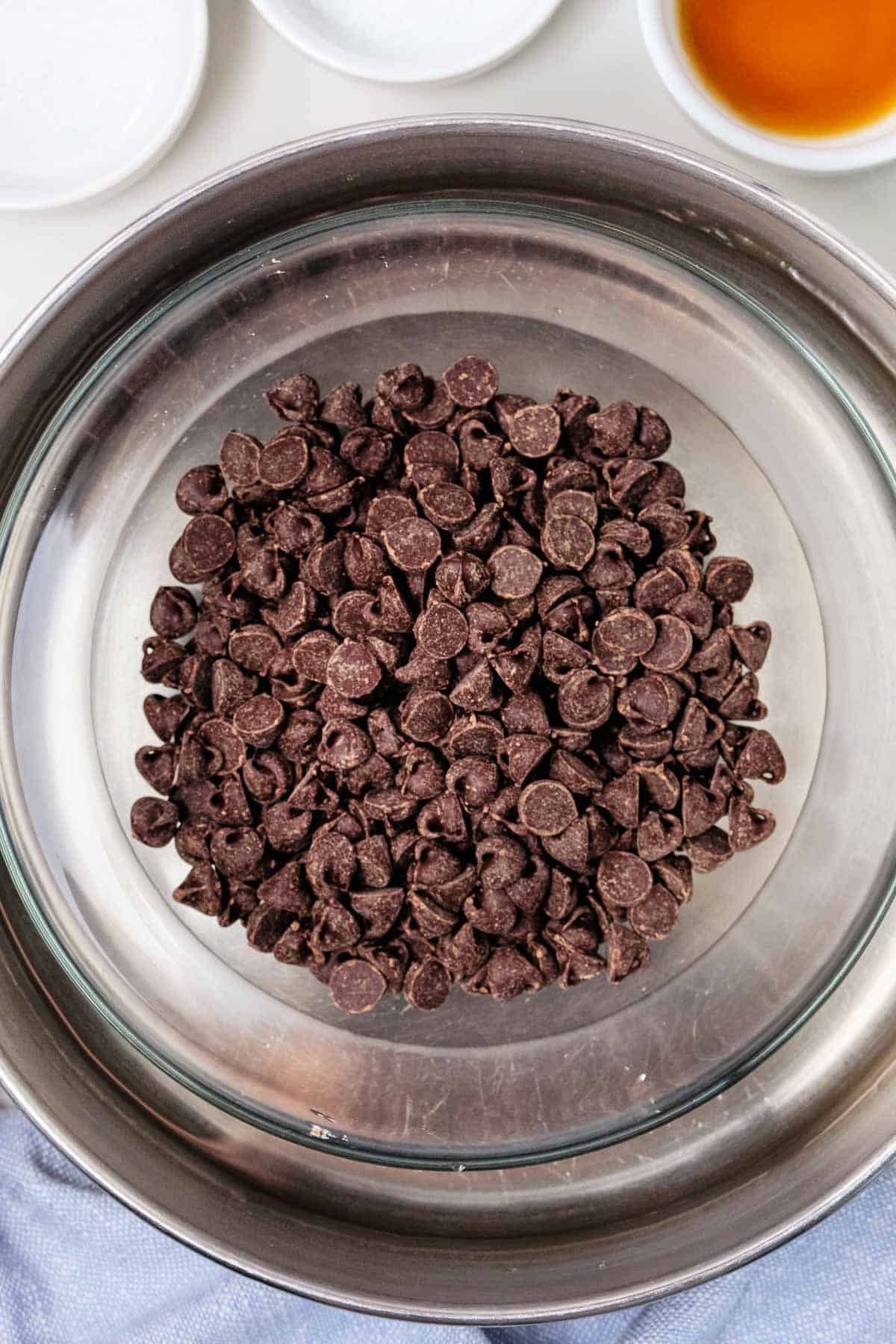 chocolate chips in a glass bowl in a pot of water.