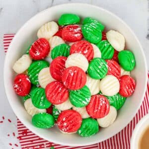 closeup of a bowl full of green, red and white cream cheese butter mints.