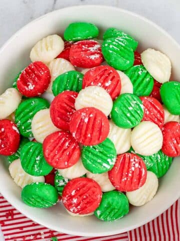 closeup of a bowl full of green, red and white cream cheese butter mints.