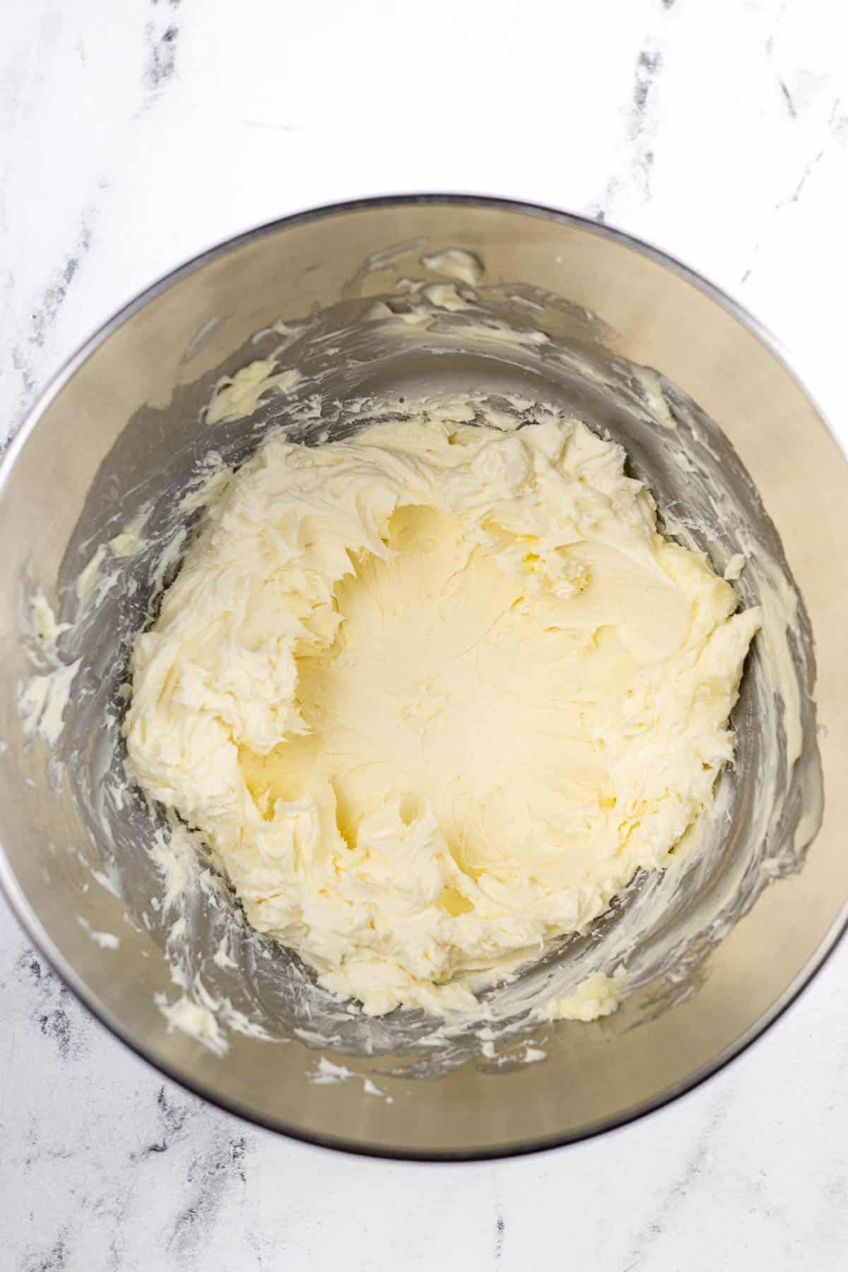 silver mixing bowl with cream butter and cream cheese.