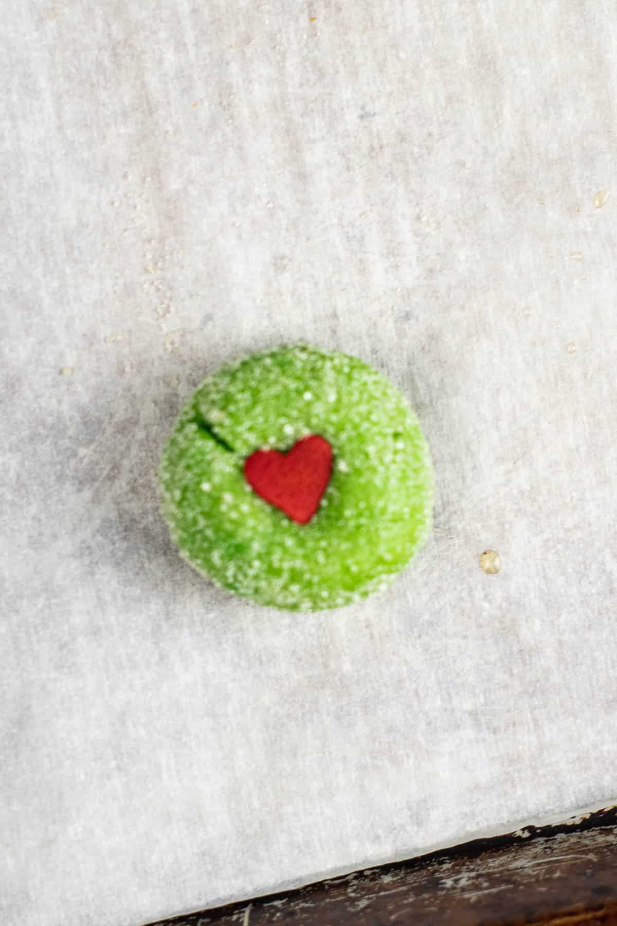 raw green cookie dough ball with a little red heart on top.