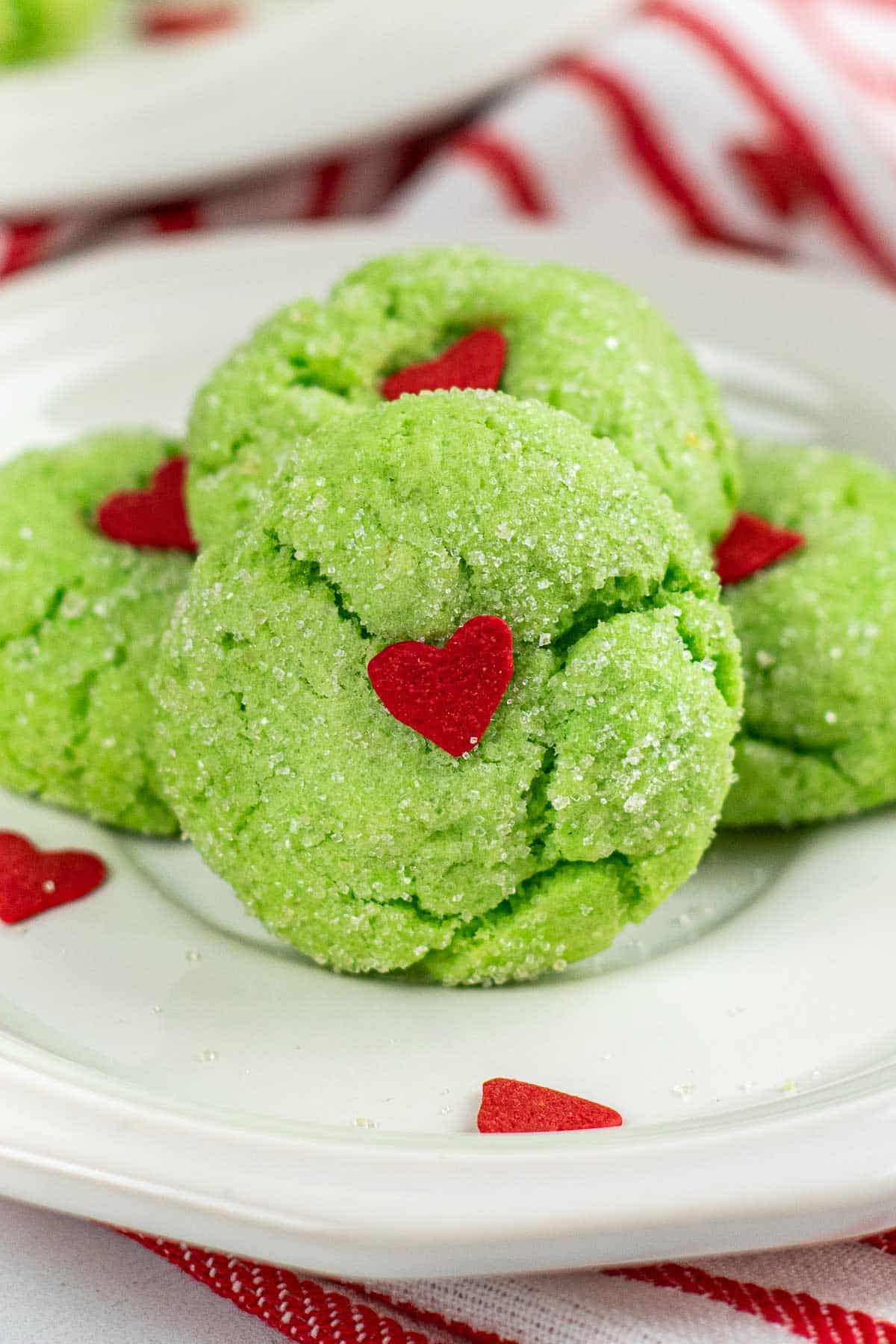 closeup of a grinch crinkle cookie with a red heart in the center.