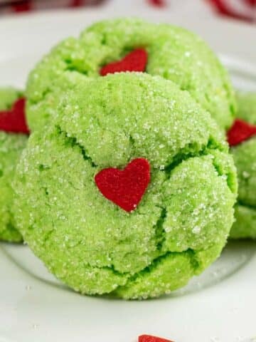 fluffy green cookie with sugared exterior and a red candy heart in the center.