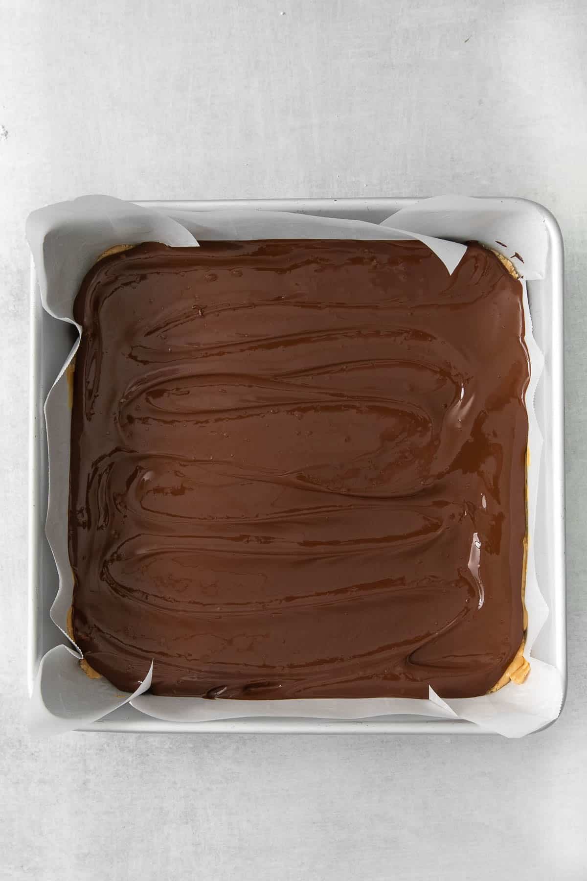melted chocolate spread in a square metal baking dish.