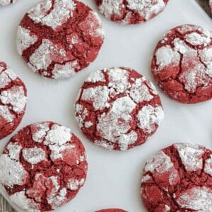 several red velvet crinkle cookies on a white background.