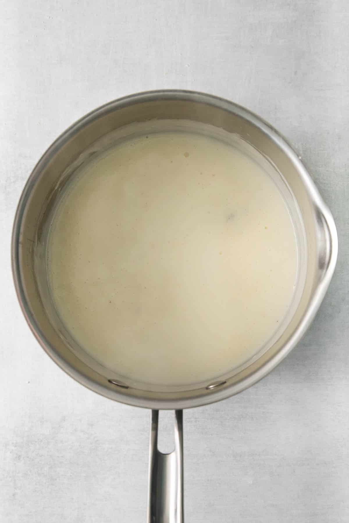stainless steel pan with cheese sauce.