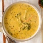 closeup of broccoli cheese soup in a white bowl.
