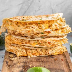 a stack of four buffalo chicken quesadillas on a cutting board.