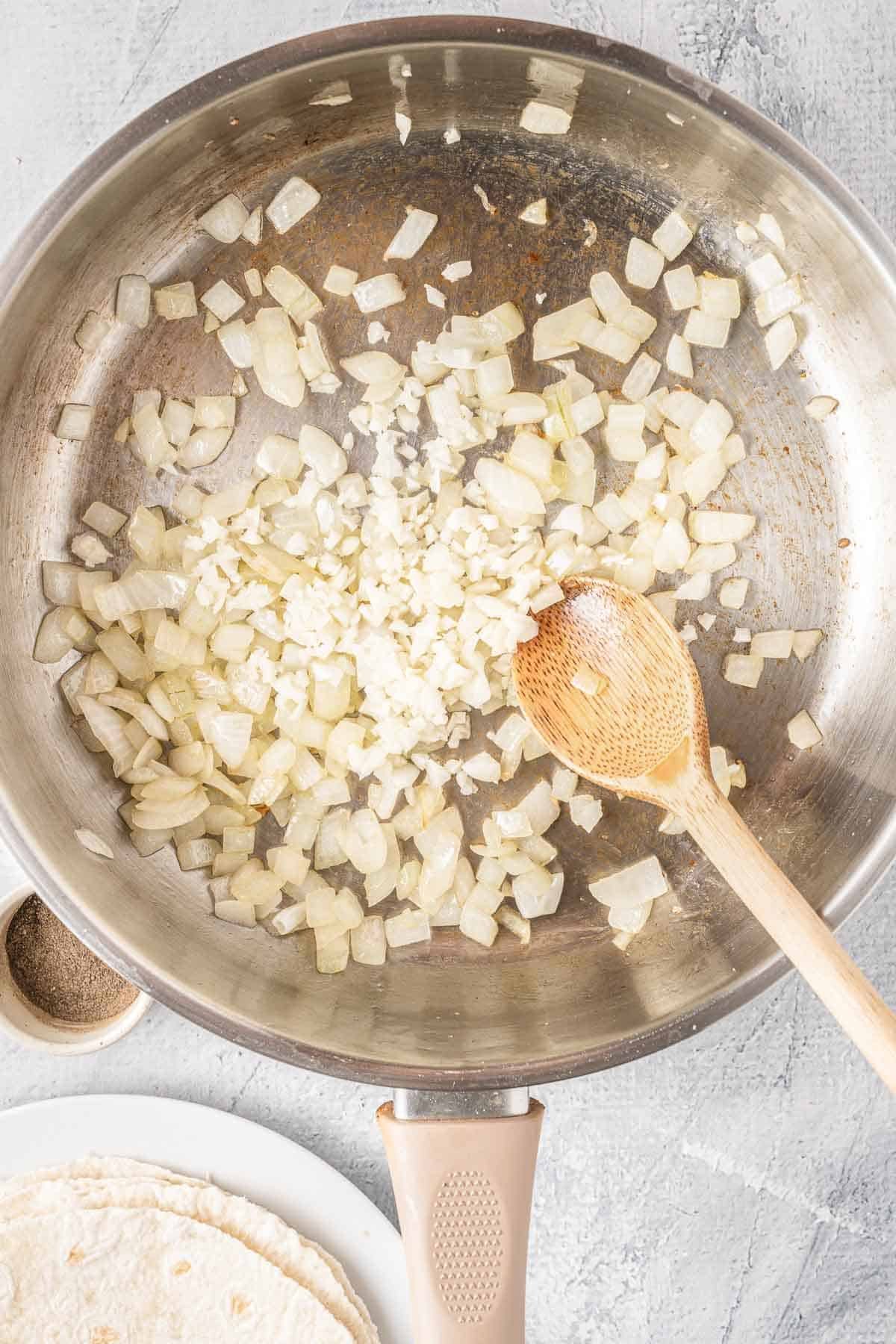 cooked diced onions in a stainless steel skillet.