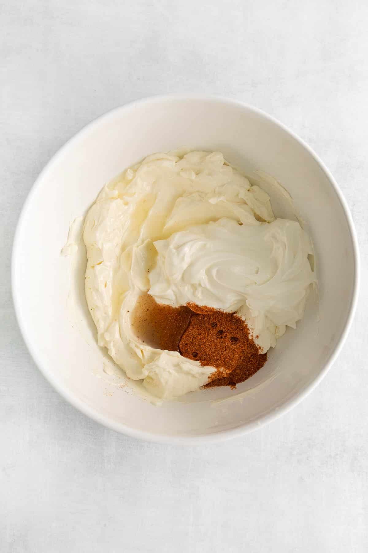 white bowl with softened cream cheese with spices.