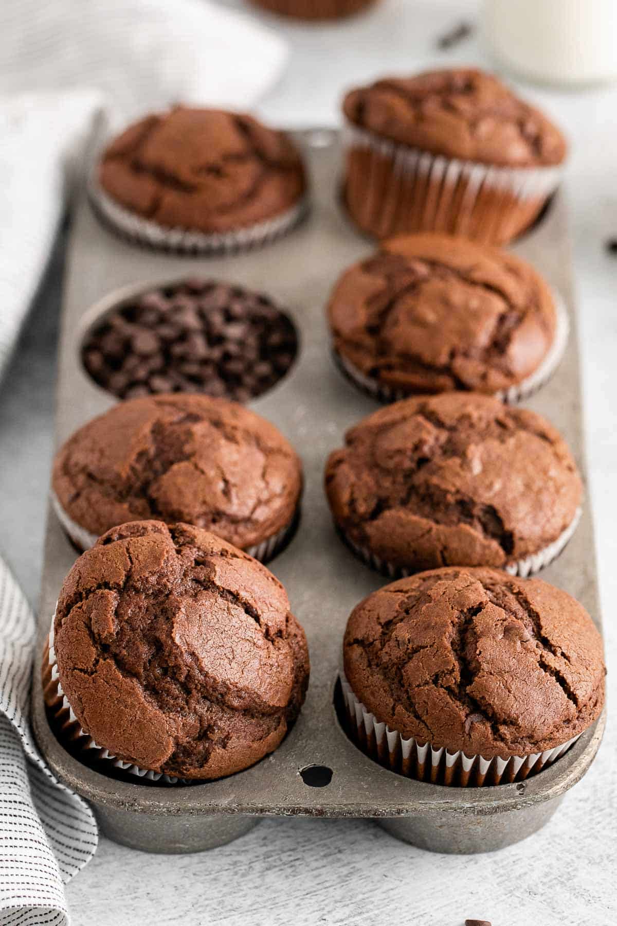 eight chocolate muffins in a muffin tin.