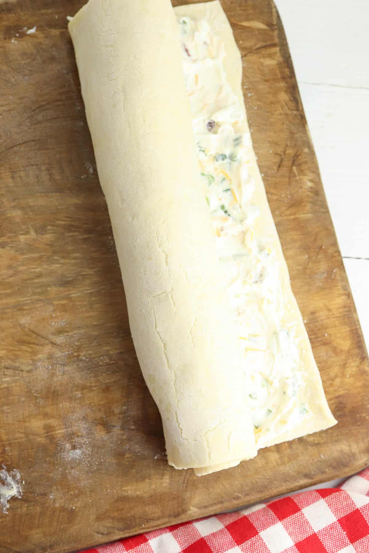 puff pastry dough rolled into a log with cream cheese mixture in the center.