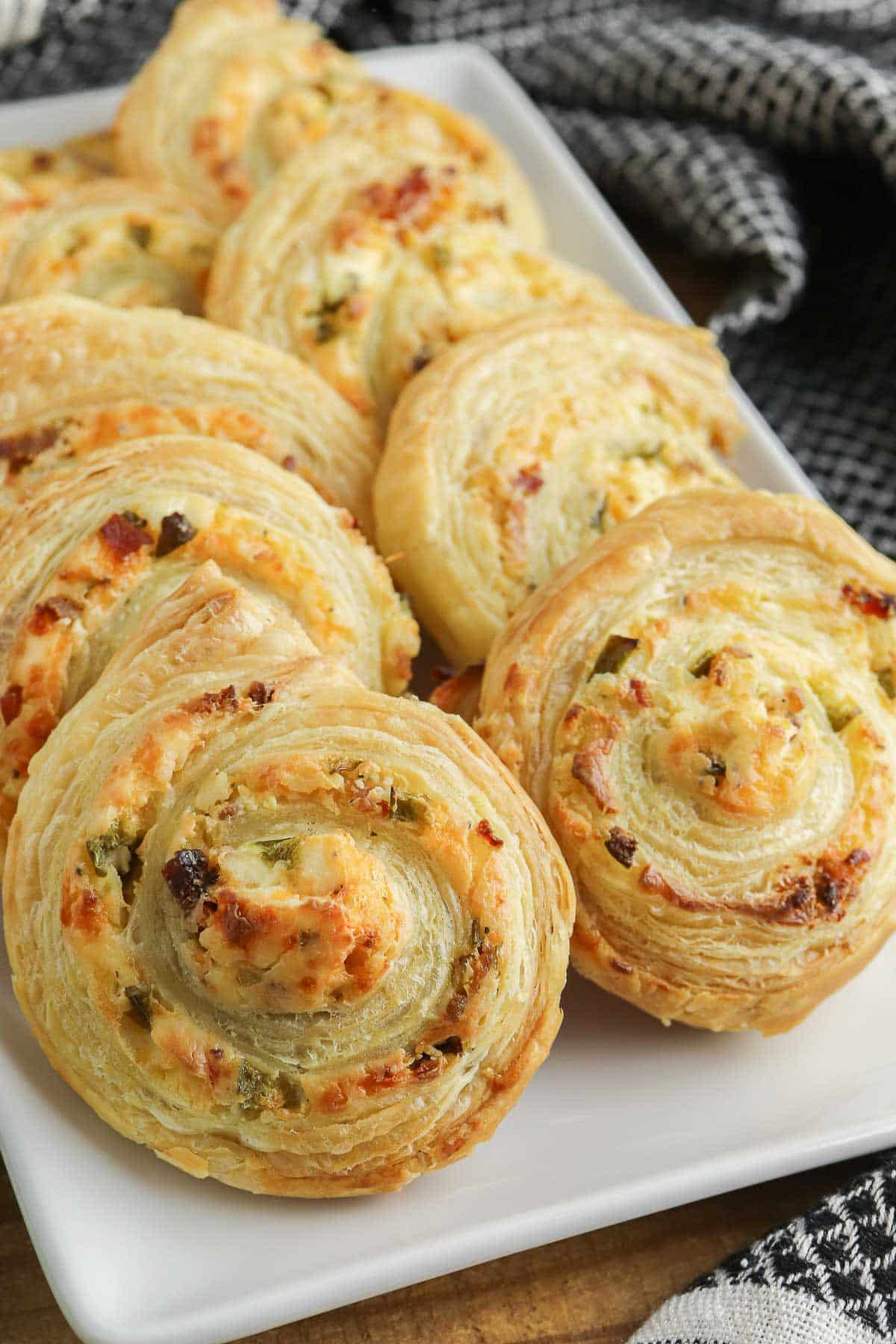 several jalapeno popper pinwheels on a white serving plate.