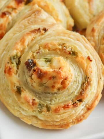 closeup of a puff pastry jalapeno popper pinwheel with cream cheese.