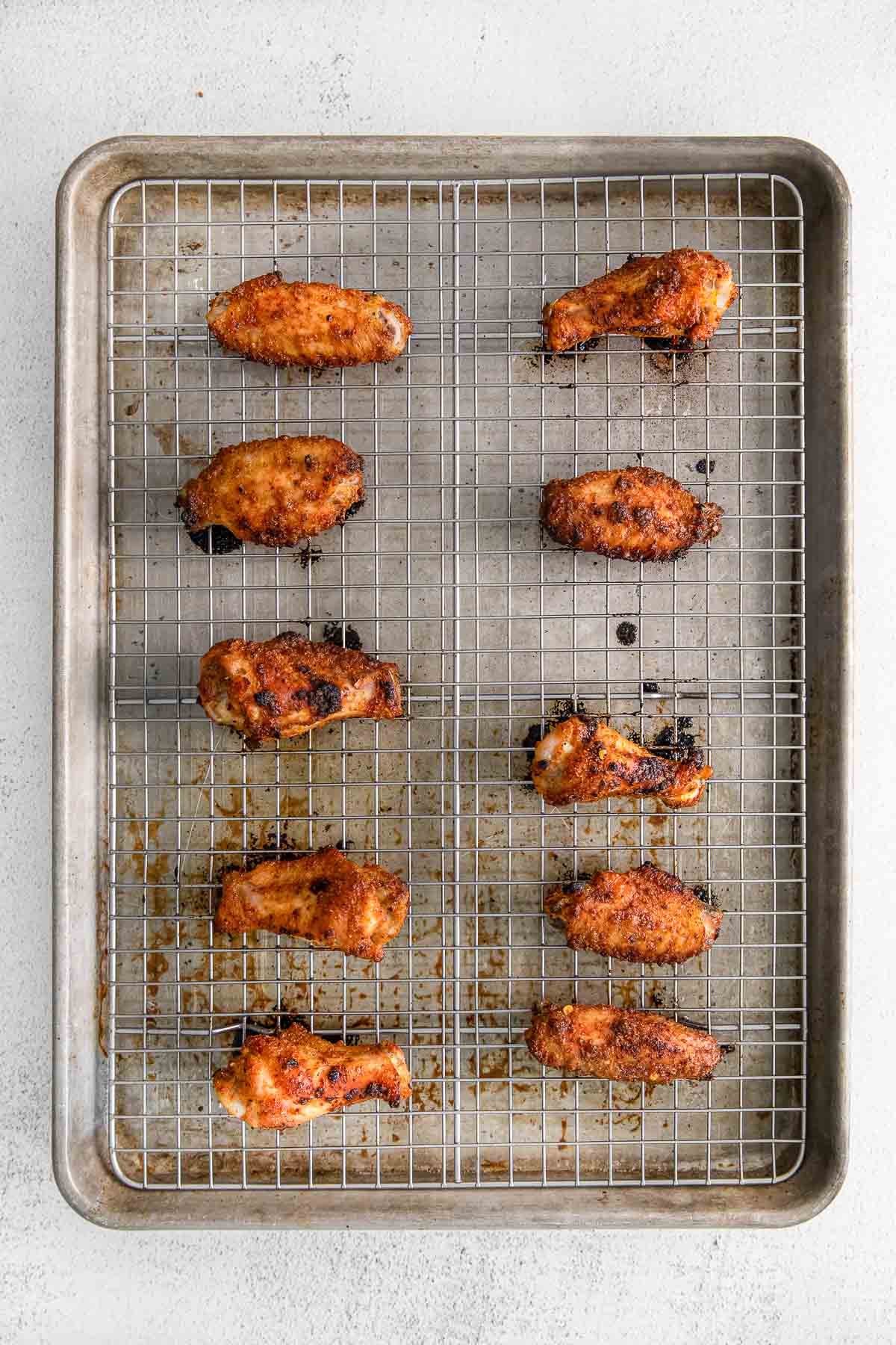 ten cooked chicken wings on a wire rack lined baking sheet.