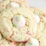 several sugar cookie blossoms cookies stacked on a plate.