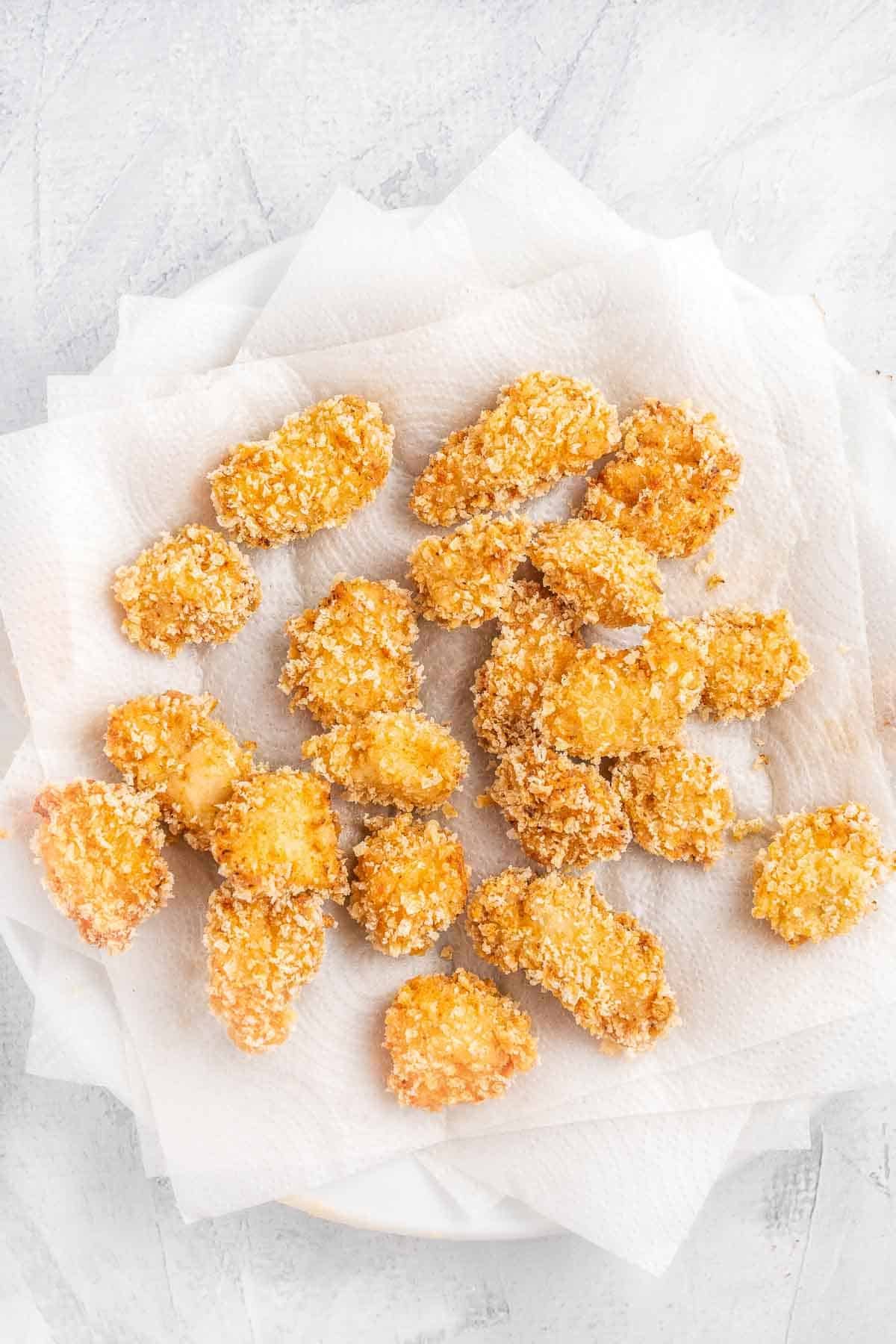 crispy fried chicken nuggets on white paper towels.