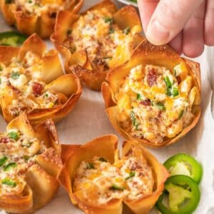 closeup of a wonton cup filled with cream cheese, bacon and jalapeno mixture.