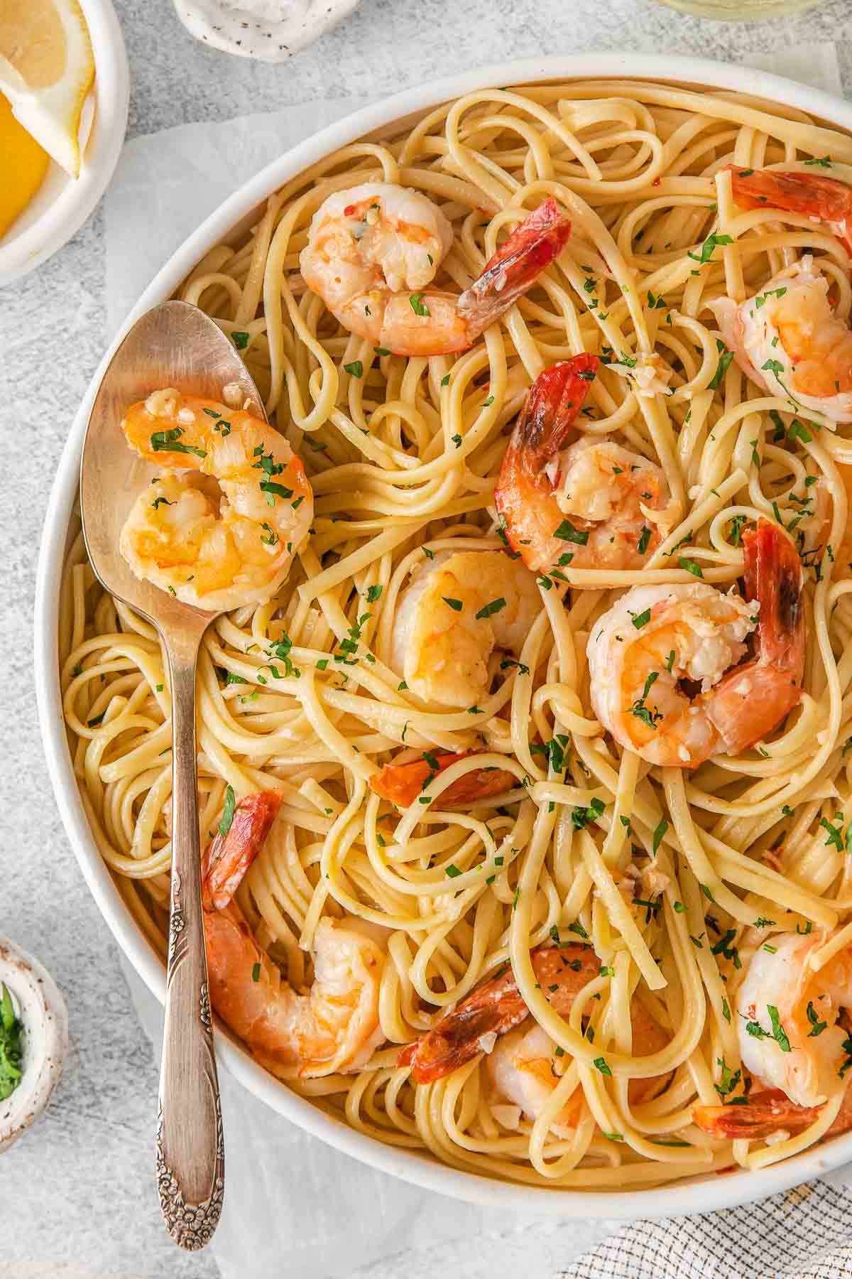 close up of linguine and shrimp in white bowl.