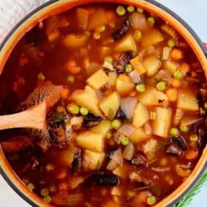 closeup of vegetable soup with diced potatoes in a tomato broth.