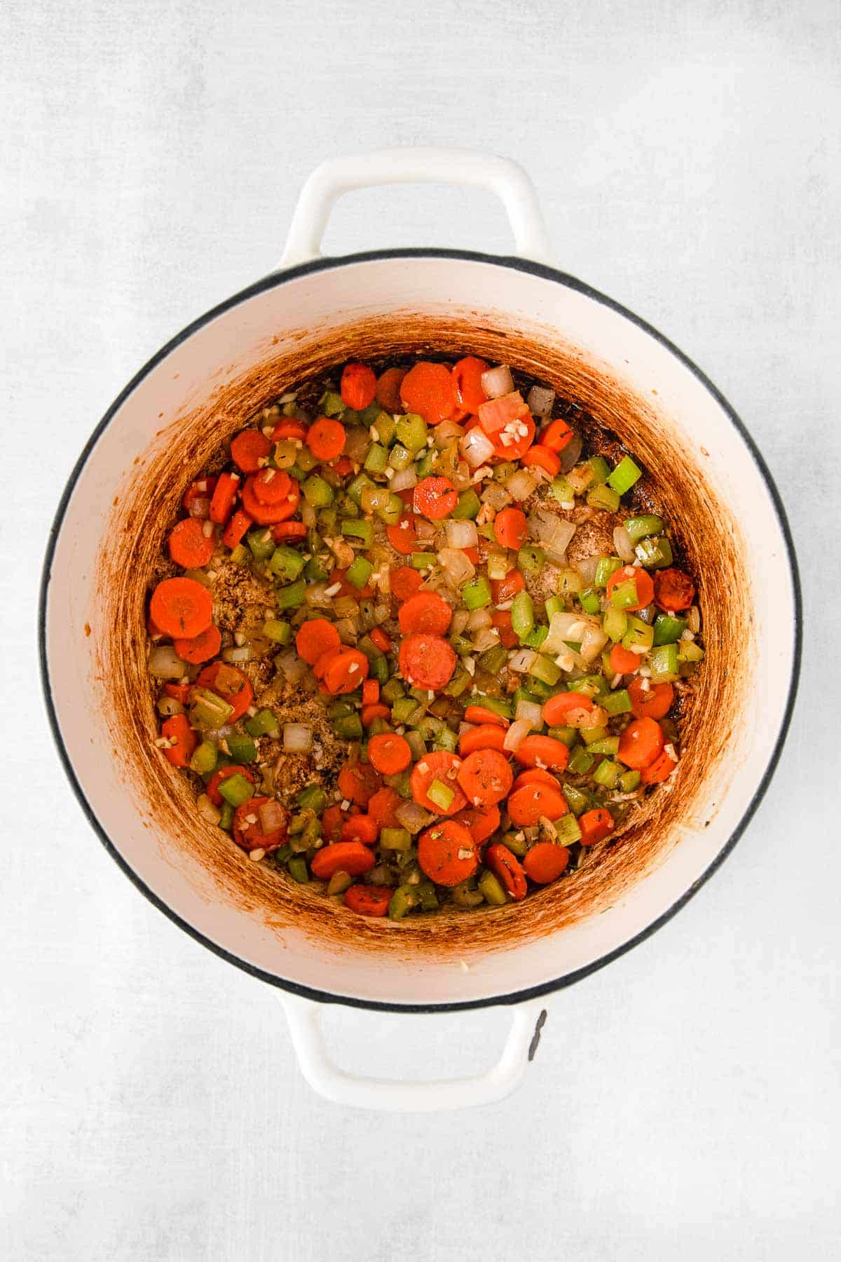 white soup pot with sautéd onions, carrots and celery.