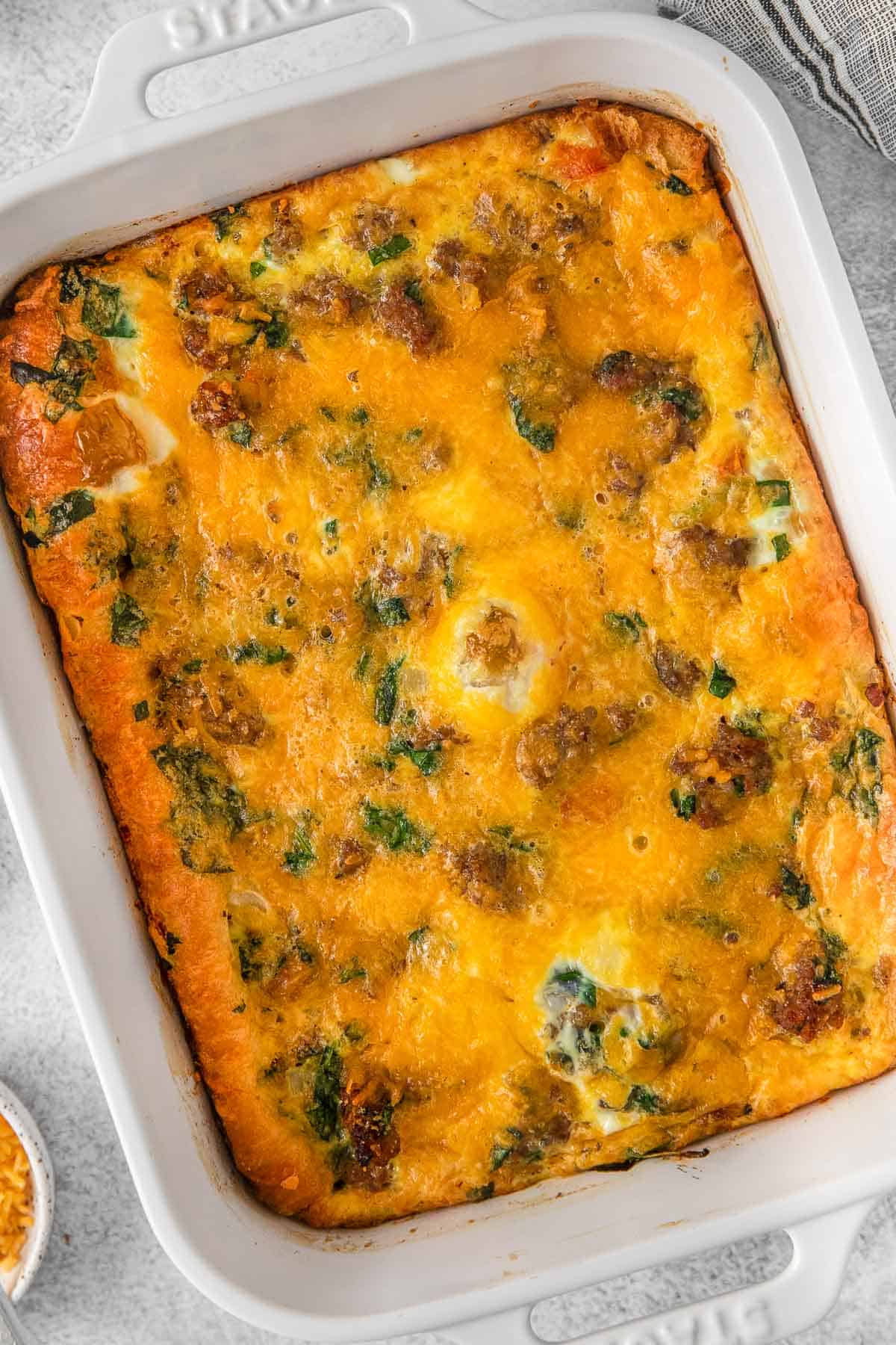 Breakfast egg casserole with sausage in white rectangle pan.
