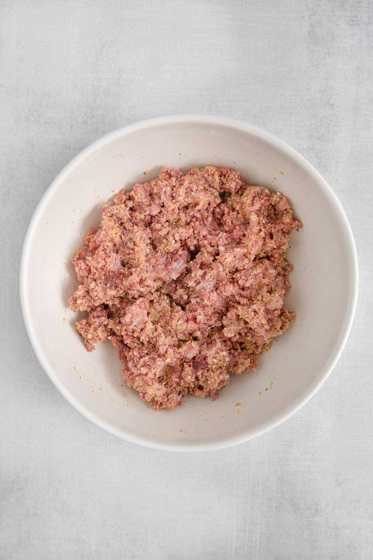 white bowl of raw ground meat.