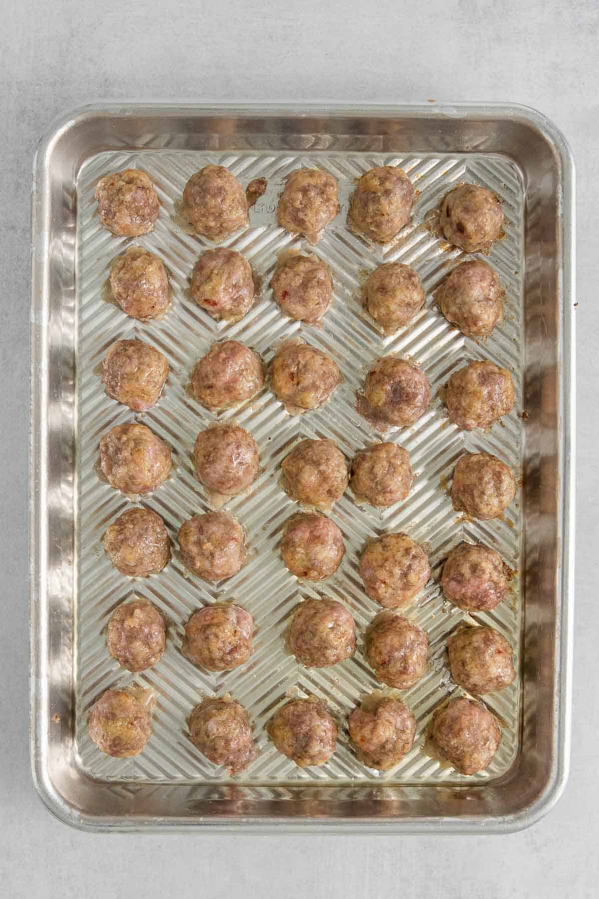 baking sheet full of baked meatballs.