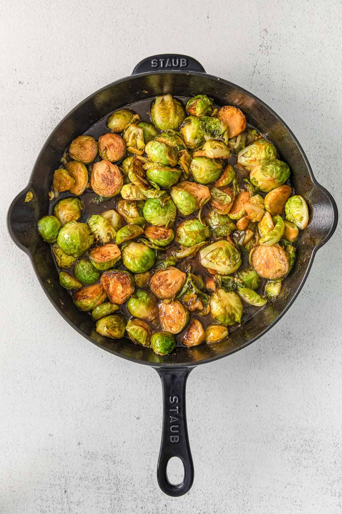 Iron skillet with brussel sprout cooking.