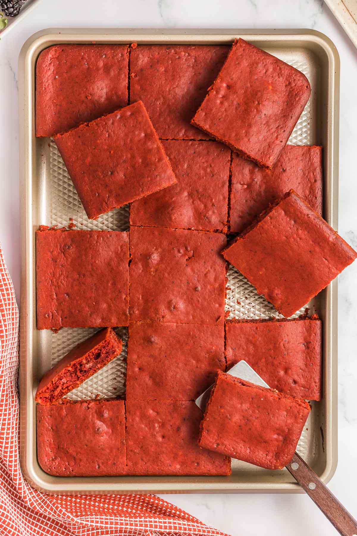 Sheet pan full of red velvet pancakes cut into squares.