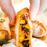 southwestern egg roll being dipped in a creamy ranch dressing.