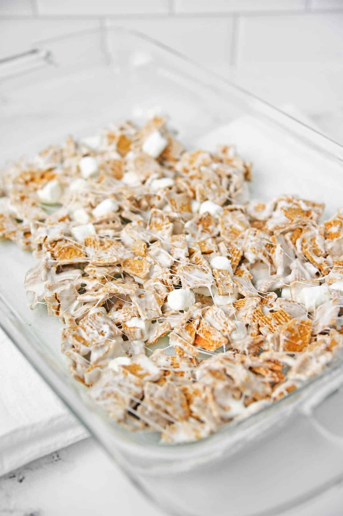 The cereal marshmallow mixture pressed evenly to the bottom of the glass baking dish.