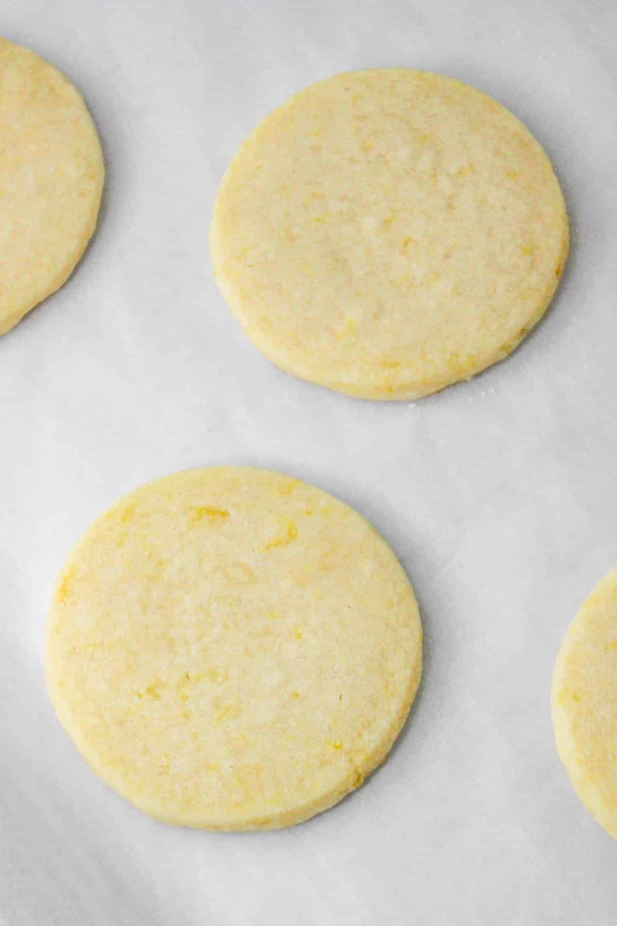 Uncooked shortbread cookies on waxed paper.