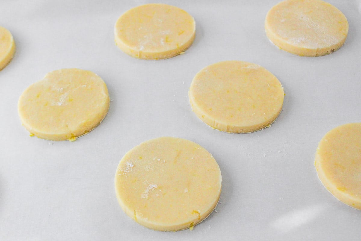 Several uncooked lemon shortbread cookies on waxed paper.