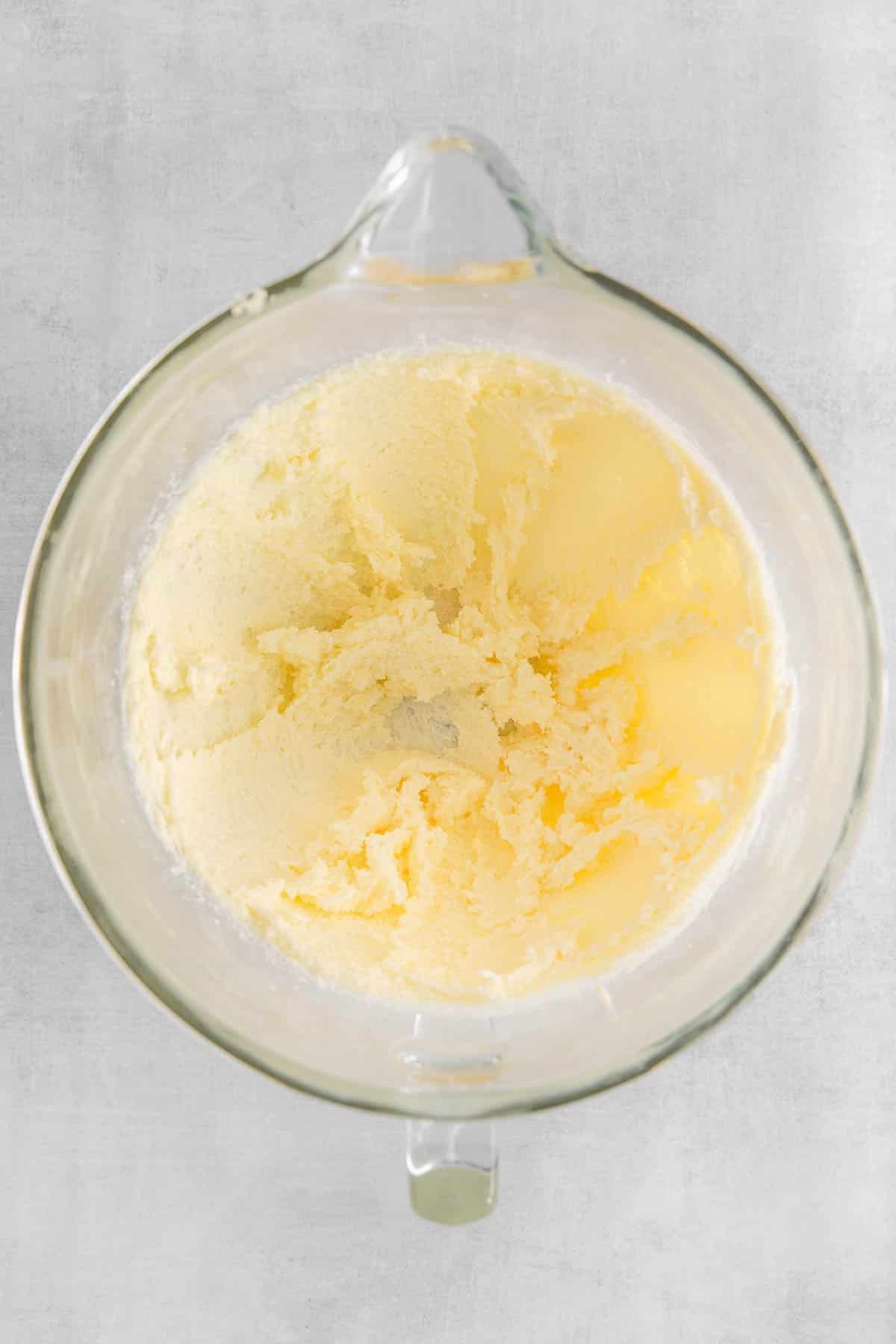 Butter and granulated sugar whipped together in glass mixing bowl.