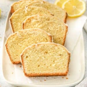 Multiple lemon pound cake slices laid on white plate.