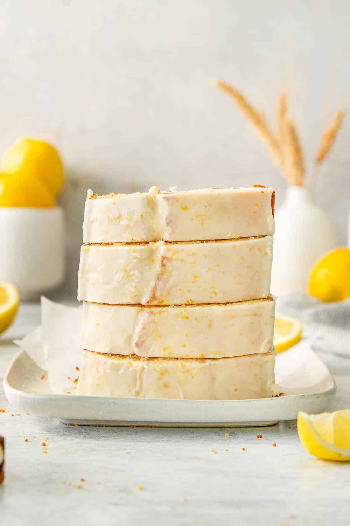 Stack of four slices of lemon pound cake on white plate.