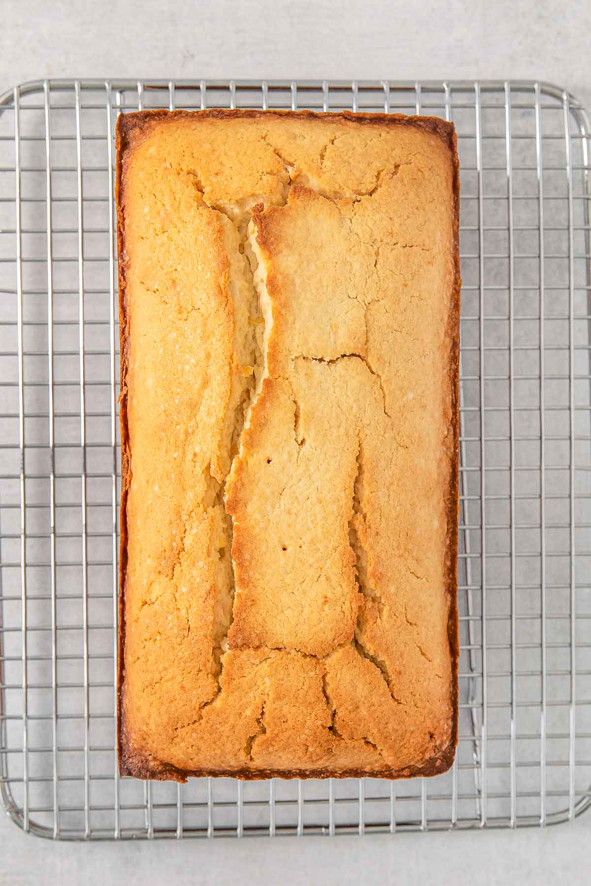 Baked lemon pound cake on wire cooling rack.