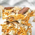 Three golden graham cereal bars stacked on top of each other with Hershey bars pieces on top.