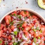 white bowl full of watermelon salsa with red onions and cilantro and text overlay that reads Easy watermelon salsa