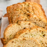 three slices of zucchini bread on bread board.