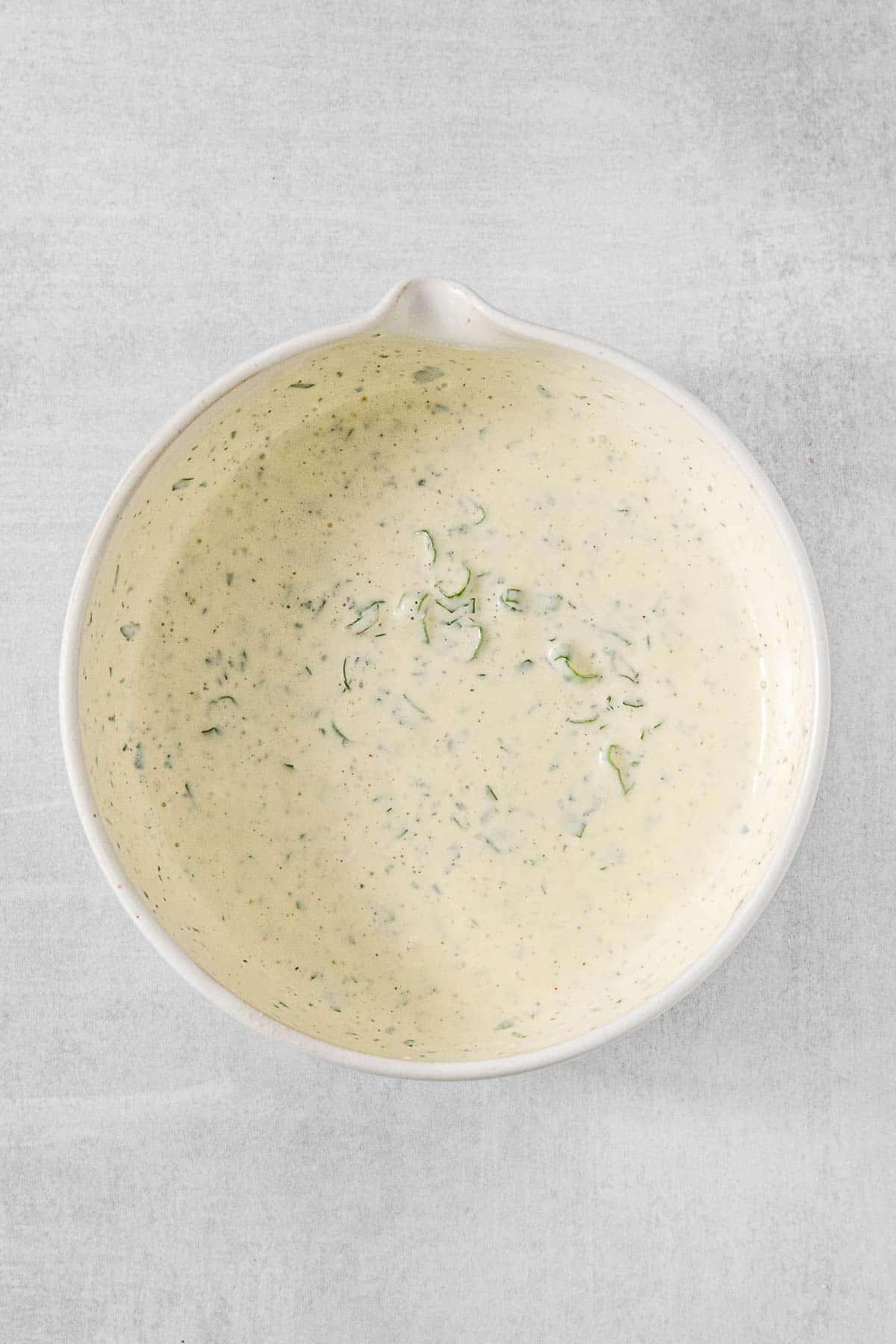 Salad dressing in a white mixing bowl.
