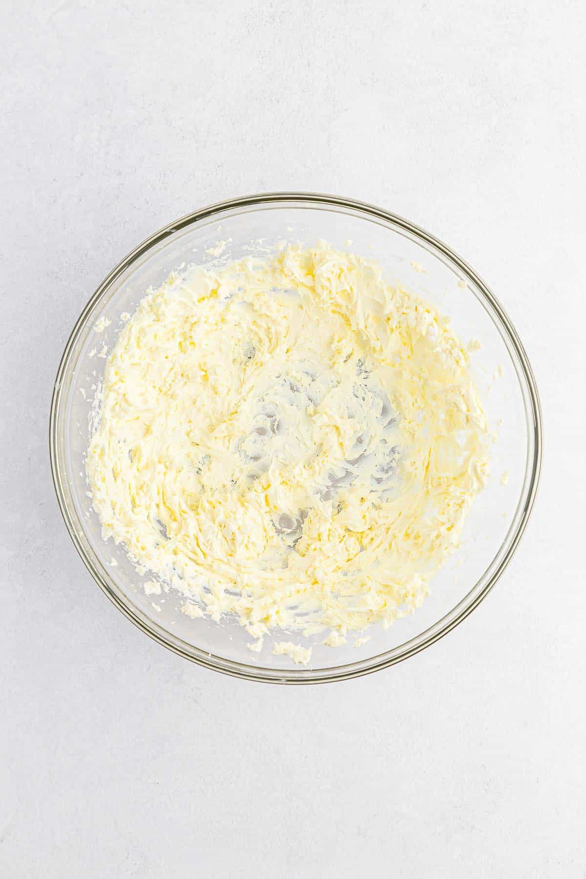 Cream cheese creamed in a glass mixing bowl.