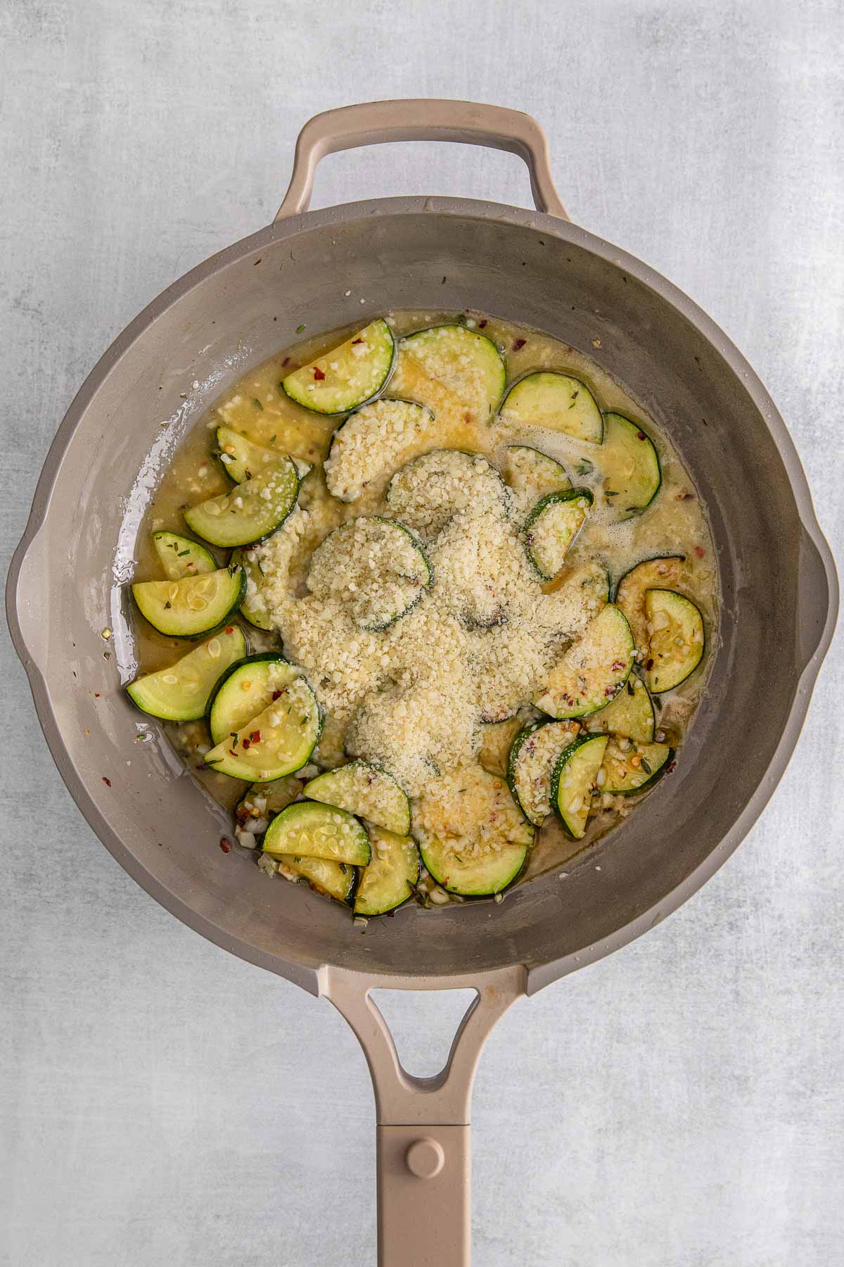 Ingredients added to zucchini in cooking pan.