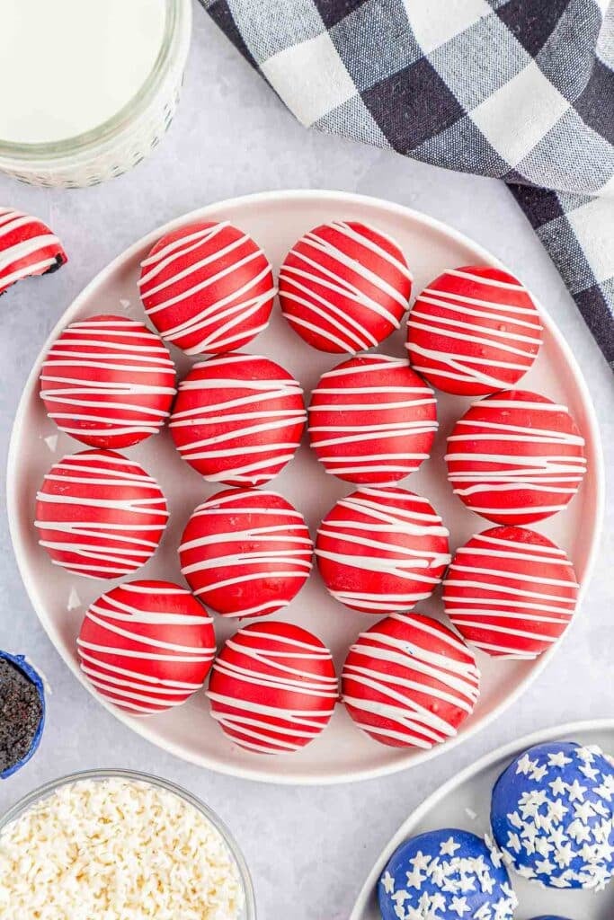 Large white plate of red oreo balls.