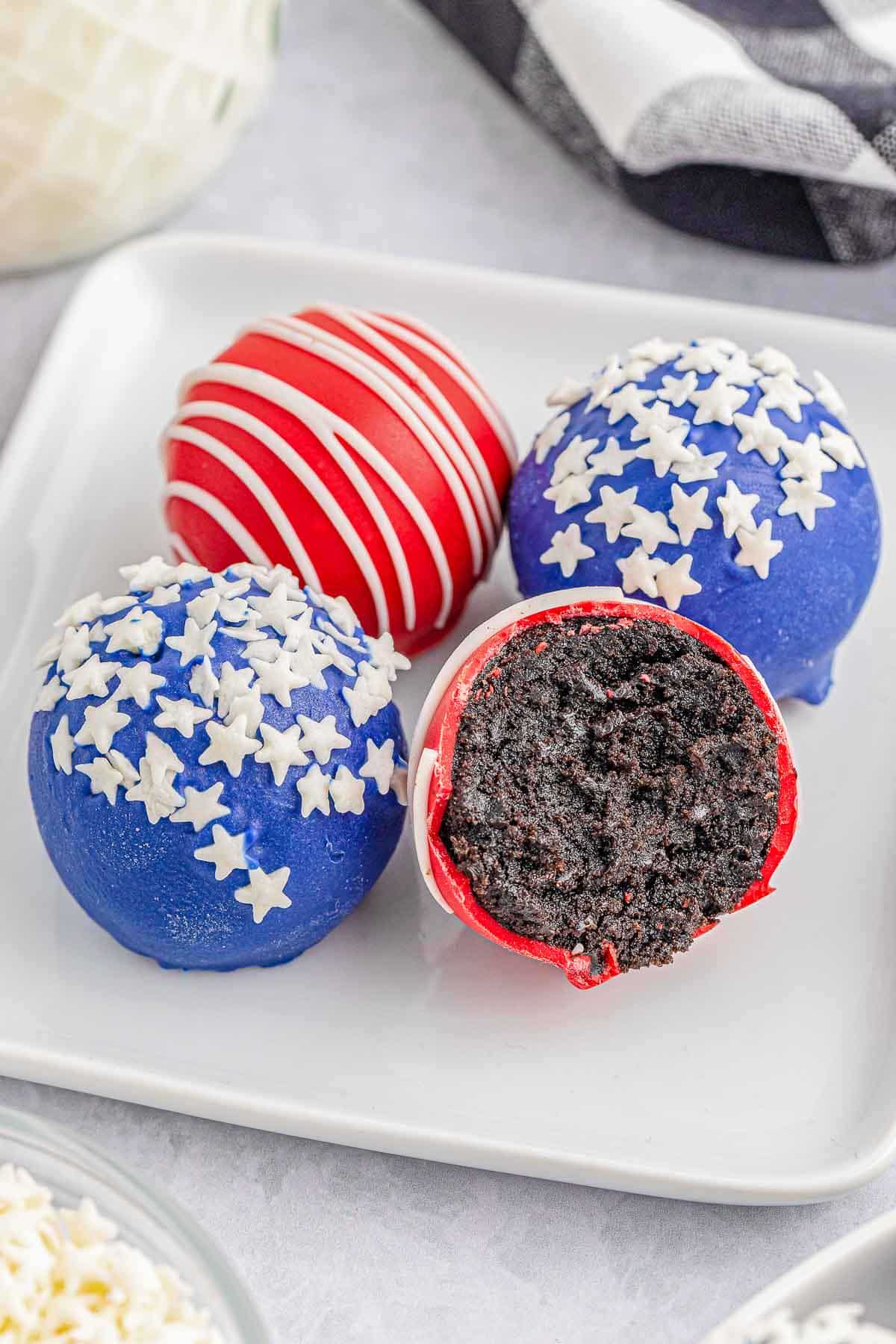 four oreo balls on a white plate.